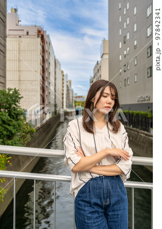 困った表情の若い女性　後楽橋 97842341