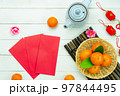 Chinese language mean rich or wealthy and happy.Top view aerial image decoration Chinese new year  lunar new year holiday background concept.Flat lay red orange with blossom on modern  white table. 97844495