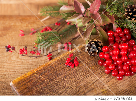 Christmas background made of ipadoub spruce branches, cones, red viburnum berries on a dark wooden rustic background. Christmas background. Copy space for text, top view. 97846732