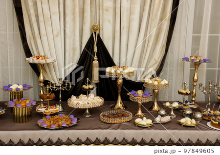 Table with cakes, sweets, candy, buffet. Dessert table for a party goodies for the wedding banquet area. Close up candy bar. Decorated delicious. 97849605