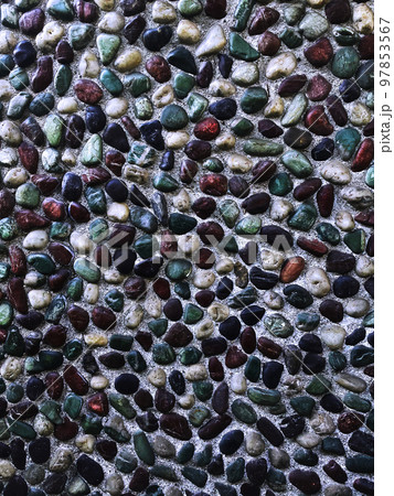 青緑色や茶色や黒色や白色の小石が埋め込まれた壁の縦長の背景画像 97853567
