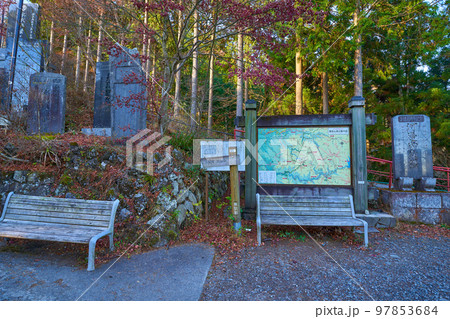 秋の青梅市御岳山 武蔵御嶽神社の随身門通過後のベンチと案内図 97853684