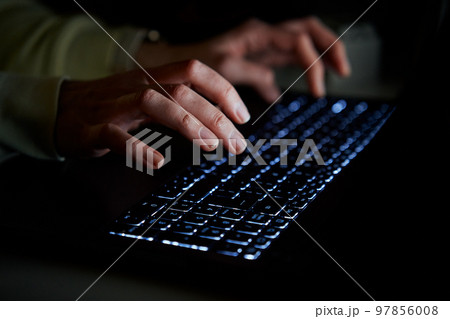 Hands of anonymous person typing on laptop keyboard at night, close up. Cyber security concept 97856008