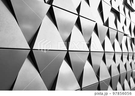 Silver wall facade with geometric shapes triangle elements. Abstract architecture details pattern. Minimal abstract background Silver wall facade with geometric shapes triangle elements. Abstract architecture details pattern. Minimal abstract background 97856056
