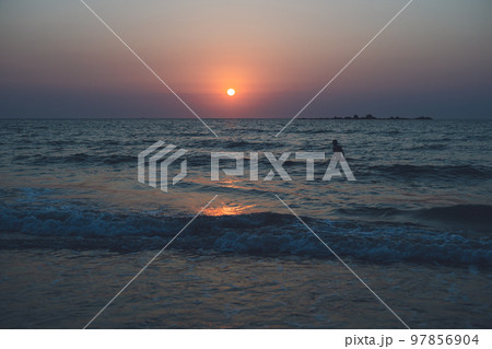 福岡県糸島 サーファーも多い幣の浜の芥屋サーフポイントから玄界灘の海に沈む夕日と夕焼け 97856904
