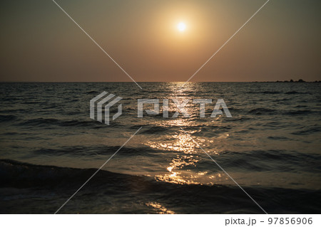 福岡県糸島 サーファーも多い幣の浜の芥屋サーフポイントから玄界灘の海に沈む夕日と夕焼け 97856906