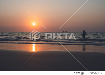 福岡県糸島 サーファーも多い幣の浜の芥屋サーフポイントから玄界灘の海に沈む夕日と夕焼け 97856907