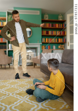 Parent scolding child addicted to modern technologies at home Parent scolding child addicted to modern technologies at home 97857331