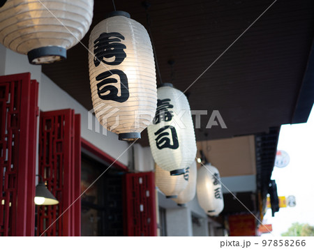 Japanese lantern hung in front of Japanese Restaurant, Japanese text on lantern is "Sushi" Japanese food. Japanese lantern hung in front of Japanese Restaurant, Japanese text on lantern is "Sushi" Japanese food. 97858266