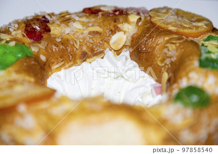 Roscon. Roscon de Reyes. Kingcake. Bun made with a sweet dough in the shape of a toroid decorated with slices of candied, candied or crystallized fruit of various colors with cream inside. 97858540