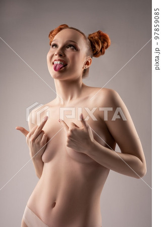 Naughty naked woman showing middle finger in gray studio Naughty naked woman showing middle finger in gray studio 97859085