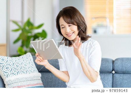リビングでタブレットを操作するシニア女性 リビングでタブレットを操作するシニア女性 97859143