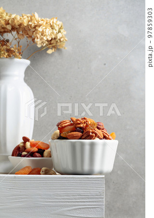 Dried fruits and nuts on a white wooden table. 97859303
