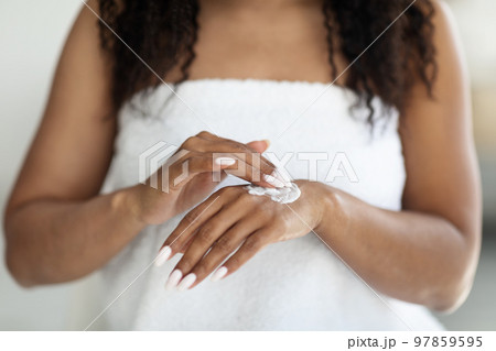 Cropped of african american lady using hand cream after shower 97859595