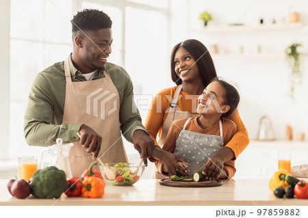 African Parents And Daughter Making Salad Together Cooking In Kitchen African Parents And Daughter Making Salad Together Cooking In Kitchen 97859882