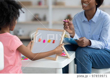 Unrecognizable child development specialist exercising with little girl, cropped Unrecognizable child development specialist exercising with little girl, cropped 97859971