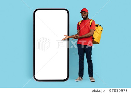 Mobile Ad. Black Delivery Guy With Thermal Backpack Pointing At Blank Smarthone Mobile Ad. Black Delivery Guy With Thermal Backpack Pointing At Blank Smarthone 97859973