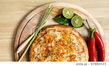 Tom Yum Pizza made by Thailand, Ingredients of Tom Yum Kung are the original curry paste, Lemongrass, Kaffir lime leaves and lime. Promotional poster for restaurant or pizza sale, Text space. 97860545