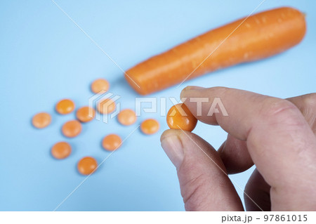 Orange vitamin D pills and a carrot Orange vitamin D pills and a carrot 97861015