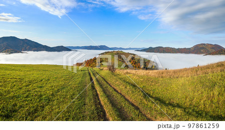Morning foggy clouds in autumn mountain countryside.  Ukraine, Carpathian Mountains, Transcarpathia. Peaceful picturesque traveling, seasonal, nature and countryside beauty concept scene. Morning foggy clouds in autumn mountain countryside.  Ukraine, Carpathian Mountains, Transcarpathia. Peaceful picturesque traveling, seasonal, nature and countryside beauty concept scene. 97861259