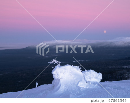Snow-covered mountain slope with fancy white trees on the night of the full moon. Amazing northern nature, winter natural background. 97861543