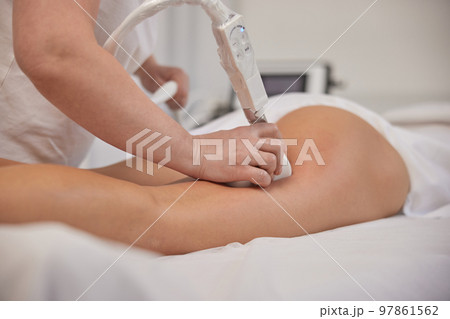 anti cellulite massage, Fighting overweight, lymphatic drainage. Young woman from beauty salon performs beauty services, body shaping, masseurs perform vacuum roller massages for clients, correcting 97861562