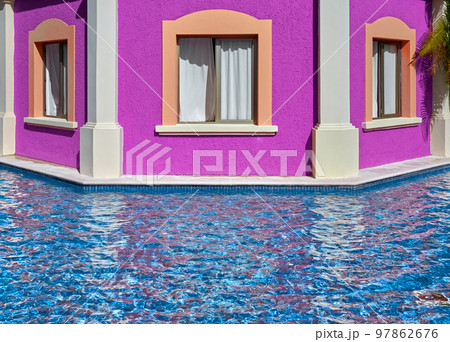 Building pink facade with windows by the pool. 97862676