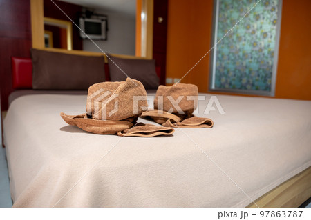 Yellow towel on bed decoration in bedroom interior, Freshly laundered fluffy towels, Towel in hotel room, Beautifully folded toiletries Yellow towel on bed decoration in bedroom interior, Freshly laundered fluffy towels, Towel in hotel room, Beautifully folded toiletries 97863787