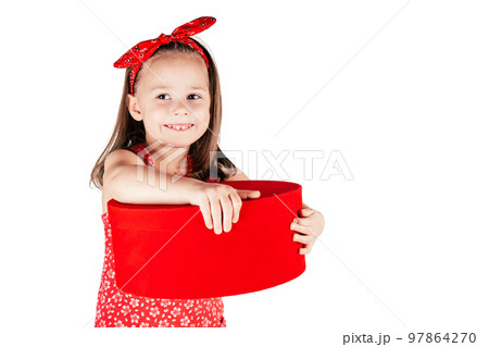 Happy little girl with smile hold big red present box. Portrait of kid isolated on white. Saint Valentine's Day concept. Happy little girl with smile hold big red present box. Portrait of kid isolated on white. Saint Valentine's Day concept. 97864270