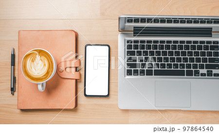 Office desk workspace with blank screen smart phone, laptop computer, notebook, pen and cup of coffee, Top view flat lay with copy space. 97864540