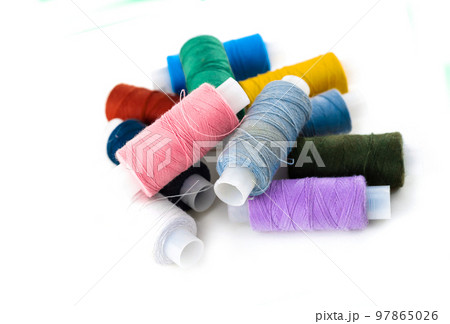 pile of thread of bright thread and gray material for embroidery of pictures and darnings on a white background pile of thread of bright thread and gray material for embroidery of pictures and darnings on a white background 97865026