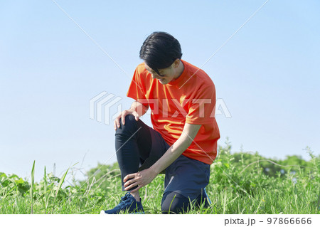 屋外で運動中に足が痛む男性 97866666