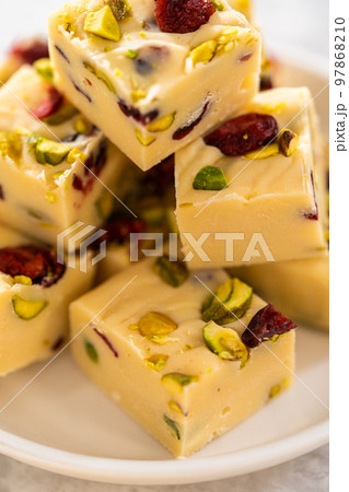 Homemade cranberry pistachio fudge square pieces on a kitchen counter. Homemade cranberry pistachio fudge square pieces on a kitchen counter. 97868210