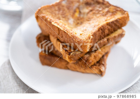 Stack of freshly baked french toast on a white plate. Stack of freshly baked french toast on a white plate. 97868985