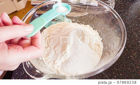 Mixing ingredients in a glass mixing bowl to make homemade pancakes. 97869238