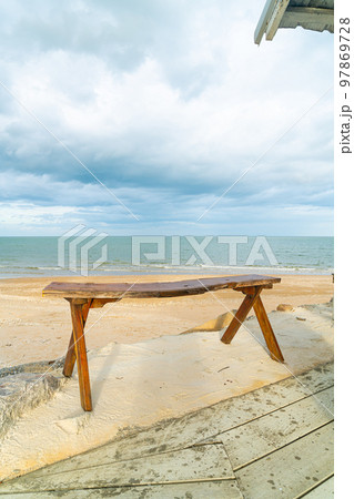 wood bench on beach with sea beach background 97869728