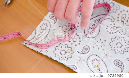 Sewing cotton face mask with a sewing machine for coronavirus outbreak. 97869804