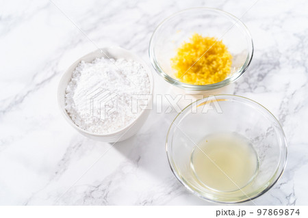 Ingredients in a glass mixing bowls to bake a lemon pound cake. Ingredients in a glass mixing bowls to bake a lemon pound cake. 97869874