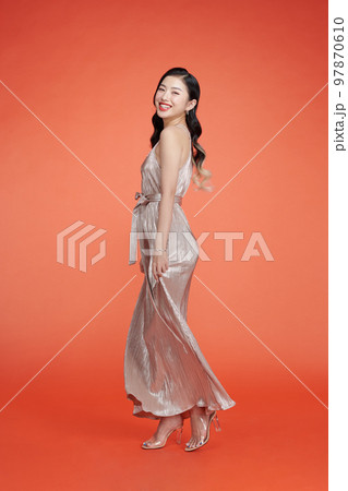 Portrait of happy woman dancing over red background wearing sequin dress. 97870610