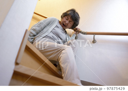 階段で転ぶシニア女性 97875429