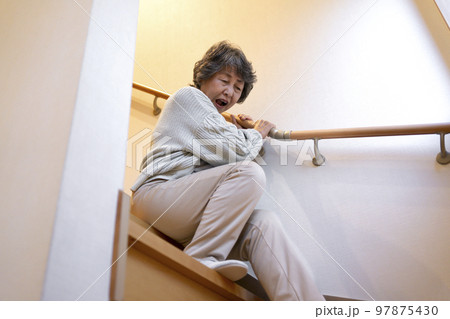 階段で転ぶシニア女性 97875430