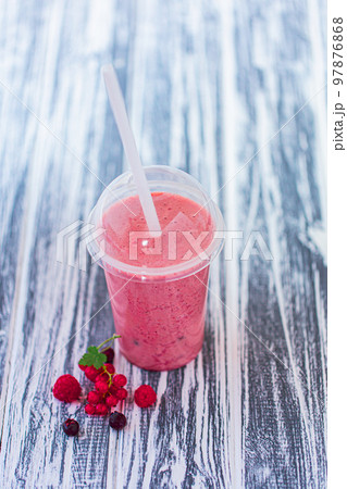 From above view of berries milkshake in plastic cup with ingredients on wood background. Vegan food From above view of berries milkshake in plastic cup with ingredients on wood background. Vegan food 97876868