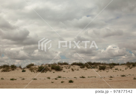 Sand dunes and cloudy sky 97877542
