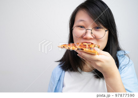 Happy glasses Asian young woman eat Pizza on white background. 97877590