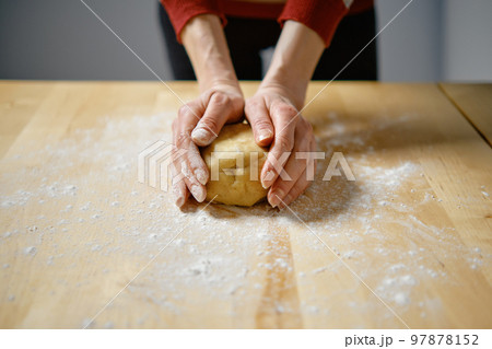 Woman kneads dough with her hands Woman kneads dough with her hands 97878152