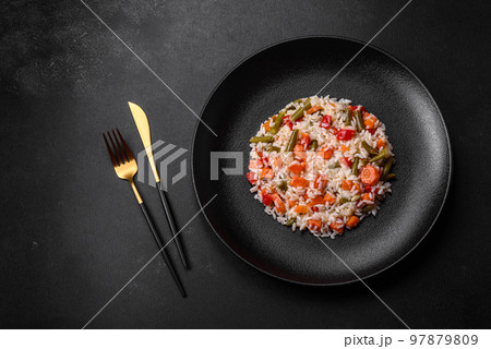 Delicious fresh risotto with vegetables, spices and herbs on a black plate 97879809