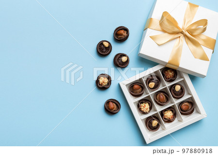White box with chocolates candies and golden tape. top view with copy space White box with chocolates candies and golden tape. top view with copy space 97880918