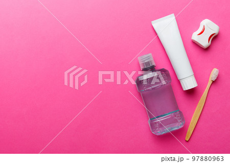 Mouthwash and other oral hygiene products on colored table top view with copy space. Flat lay. Dental hygiene. Oral care products and space for text on light background. concept Mouthwash and other oral hygiene products on colored table top view with copy space. Flat lay. Dental hygiene. Oral care products and space for text on light background. concept 97880963