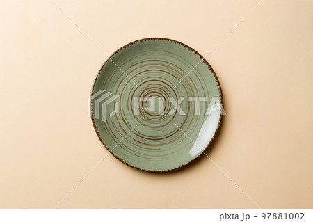Top view of isolated of colored background empty round green plate for food. Empty dish with space for your design 97881002