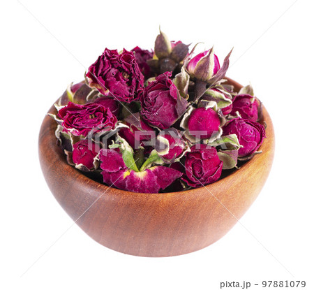 Heap of dry tea roses buds in wooden bowl, isolated on white background. Rose flower tea. Phnom Penh rose tea. Clipping path. 97881079